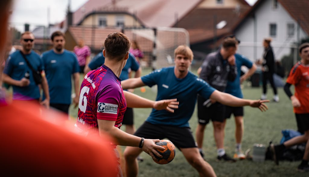 Outdoor handball practice session with players in action on a sports field in Oberviechtach, Germany.